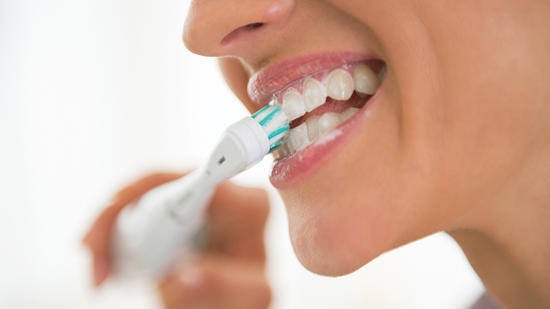 donna utilizza lo spazzolino elettrico